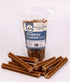 Bag of blueberry coconut dog chews with multiple treats in front on a white background